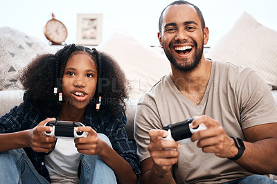 Buy stock photo Shot of a young girl playing video games with her father at home