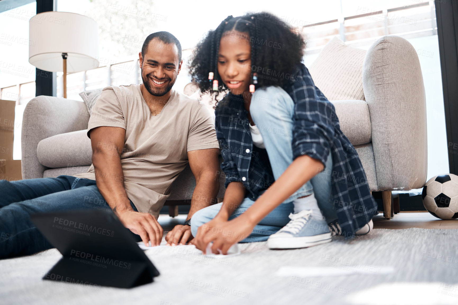 Buy stock photo Shot of a young girl using a digital tablet with her father at home