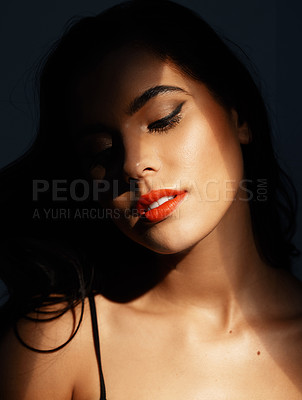 Buy stock photo Studio shot of an attractive young woman posing against a dark background