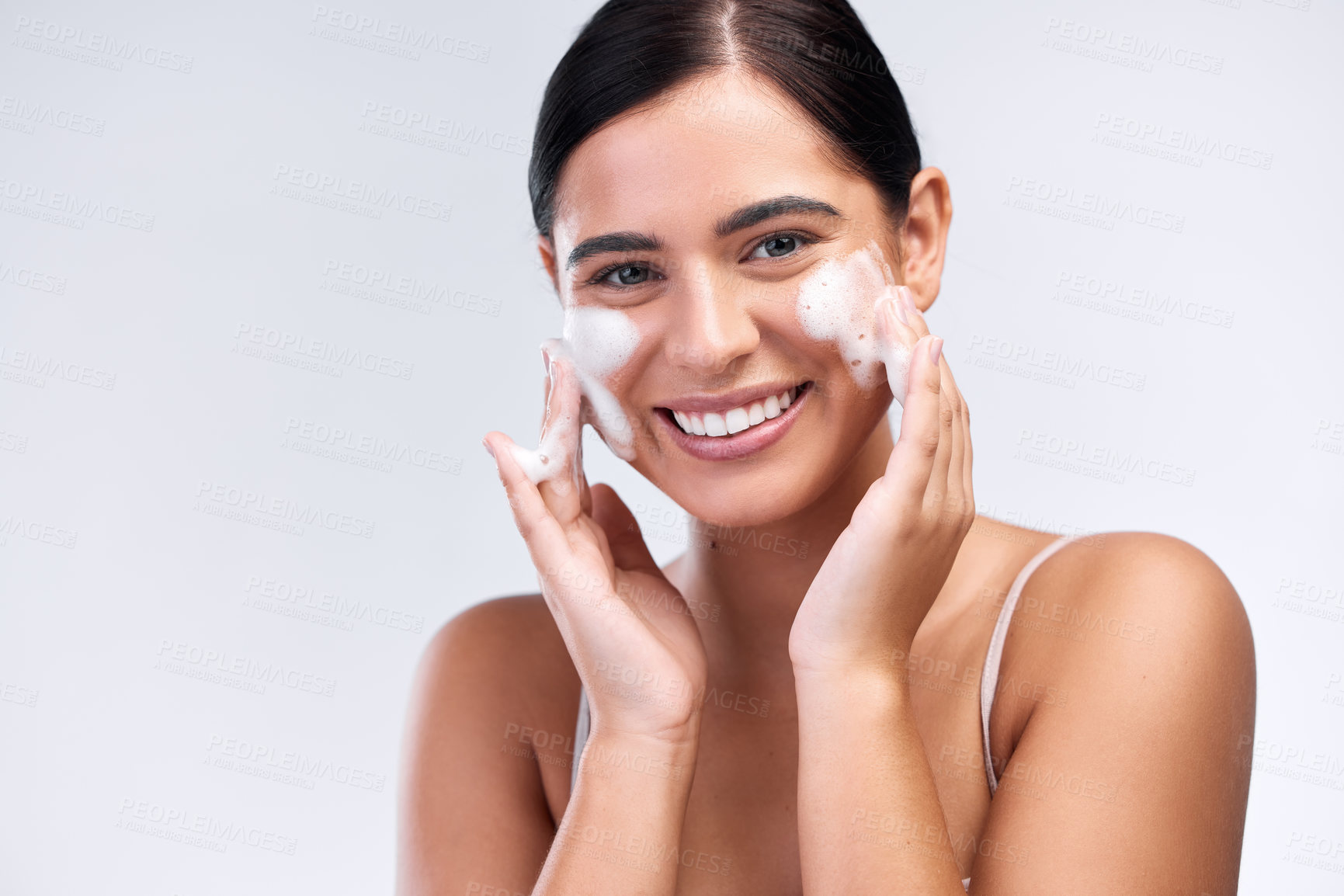 Buy stock photo Beauty, foam wash and portrait of a woman in a studio for natural, cosmetic and skincare routine. Wellness, smile and female model cleaning her face with facial cleanser isolated by white background