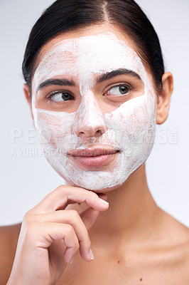 Buy stock photo Studio shot of a young woman wearing a face mask while standing against a white background