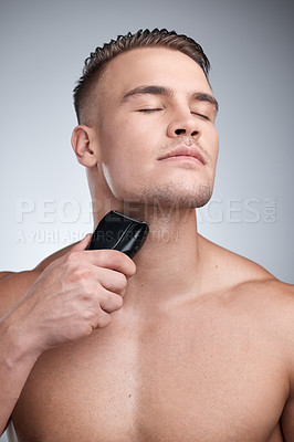 Buy stock photo Shaving beard, electric machine and man with skincare, cosmetics and dermatology on grey studio background. Person, model and guy with hair removal, facial care and aesthetic with beauty and wellness