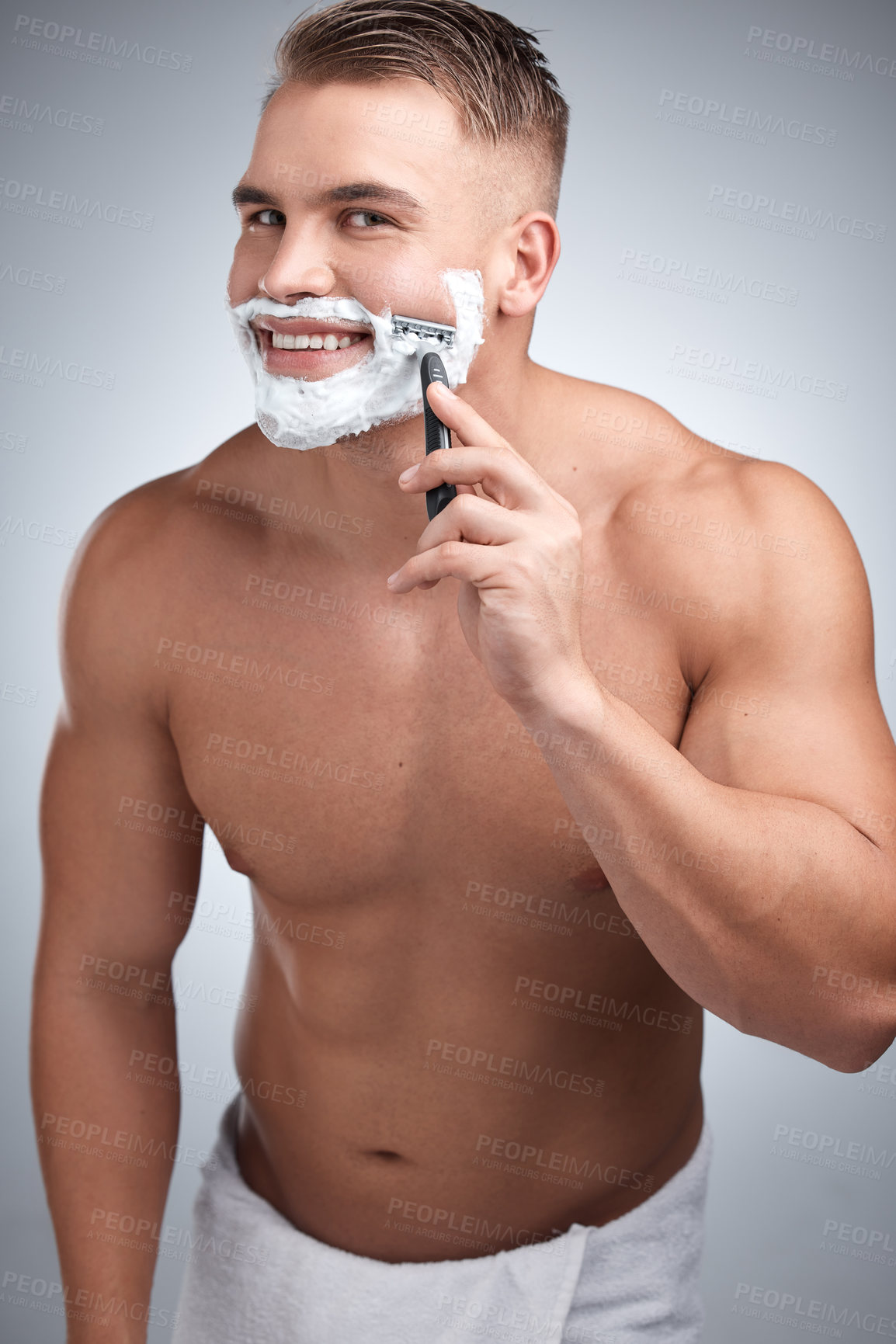 Buy stock photo Happy man, razor and portrait for shaving in studio for grooming, hair removal and towel by backdrop. Male person, body and soap for skincare, smile and facial or beard products by white background