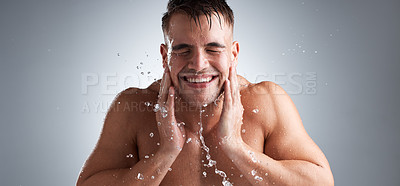 Buy stock photo Man, studio and washing face in water splash , clean and morning for health of body, banner and routine for skincare. Hygiene, happy and person in grey background of bathroom, liquid and relax