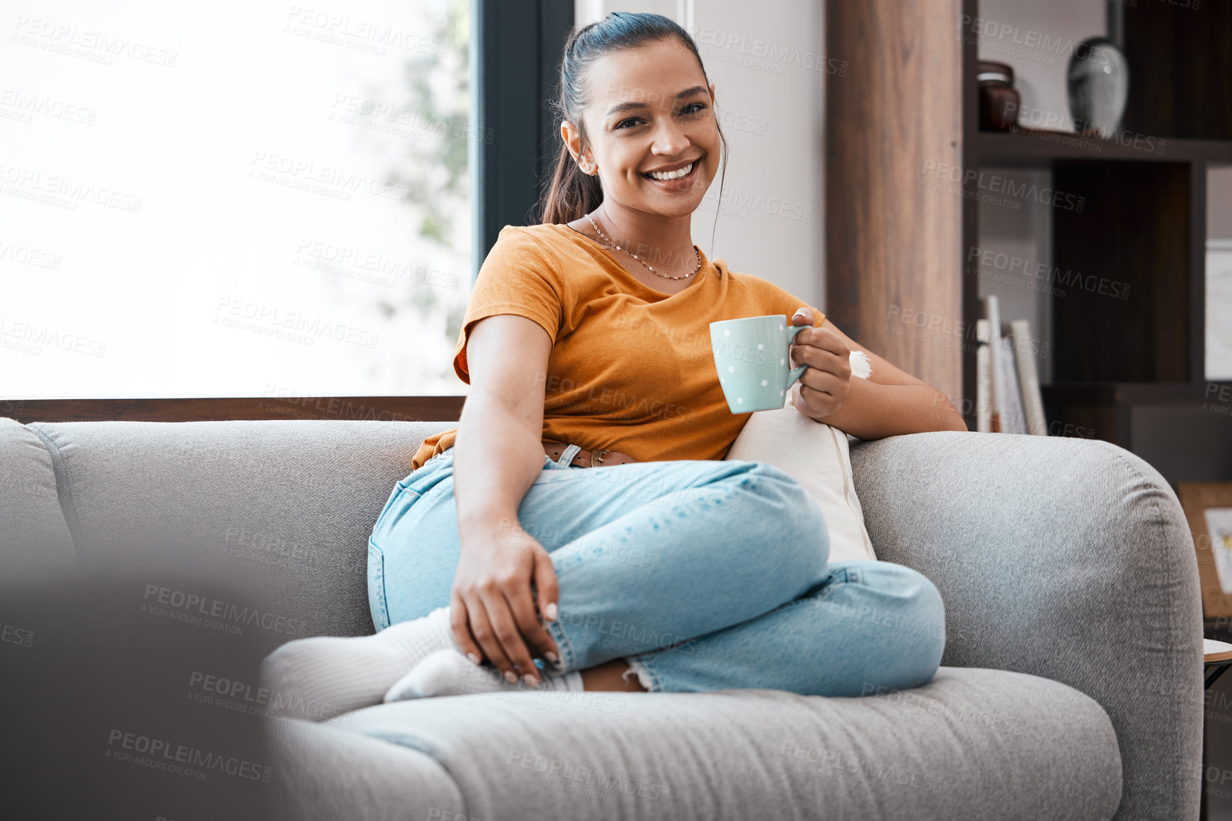 Buy stock photo Shot of a young woman relaxing on the couch at home