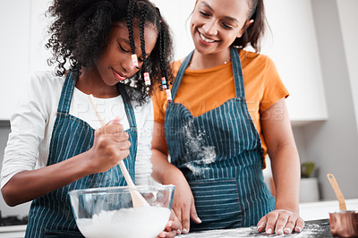 Buy stock photo Shot of a mother and daughter baking together in the kitchen at home