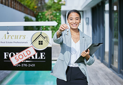 Buy stock photo Shot of a young female real estate agent holding keys to a new house that's been sold