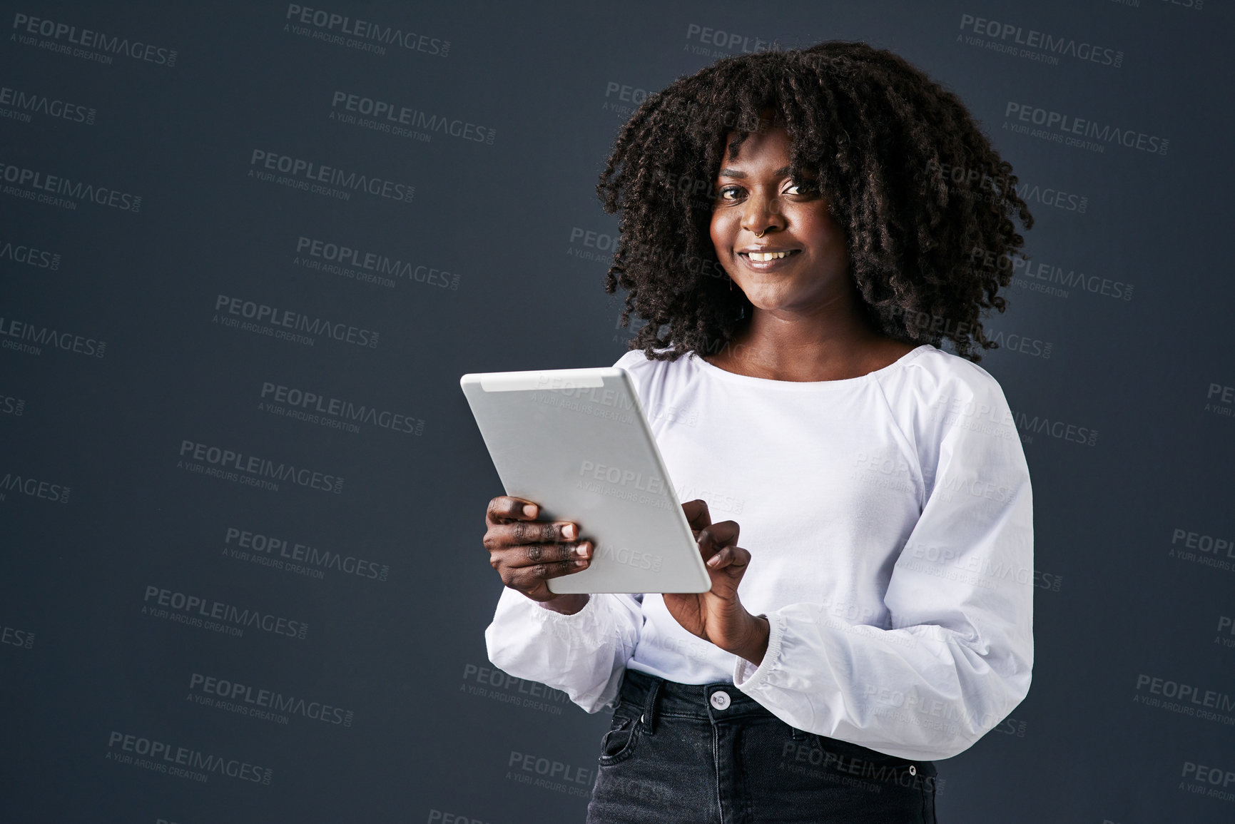 Buy stock photo Shot of a young businesswoman using a digital tablet against a studio background