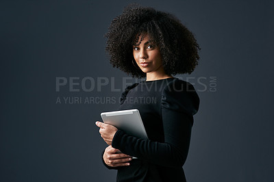 Buy stock photo Shot of a young businesswoman using a digital tablet against a studio background