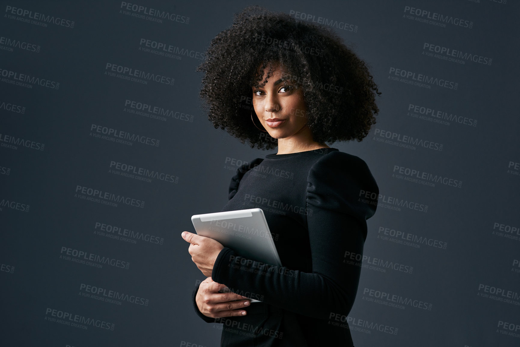 Buy stock photo Shot of a young businesswoman using a digital tablet against a studio background