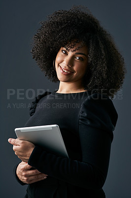 Buy stock photo Shot of a young businesswoman using a digital tablet against a studio background