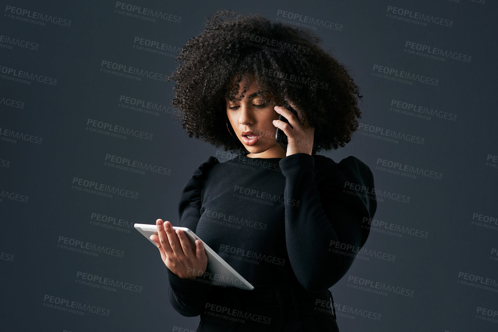 Buy stock photo Shot of a young businesswoman using her smartphone and digital tablet against a studio background