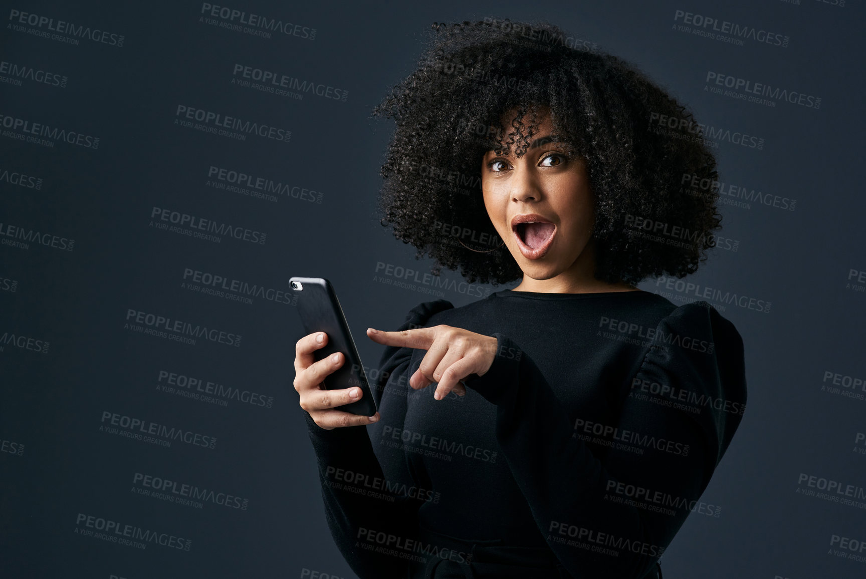 Buy stock photo Shot of a young businesswoman using her smartphone against a studio background