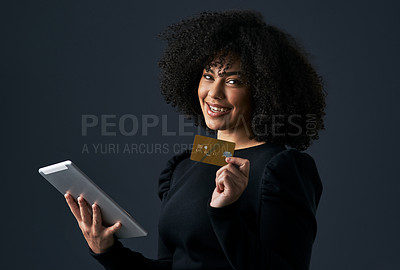 Buy stock photo Shot of a businesswoman using her tablet to shop online against a studio background
