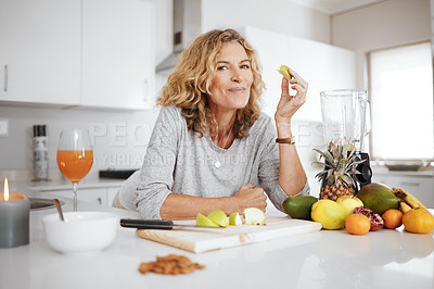 Buy stock photo Portrait, fruit salad and apple with a senior woman in the kitchen of her home for health, diet or nutrition. Smile, food and cooking with a happy mature female pension eating healthy in the house