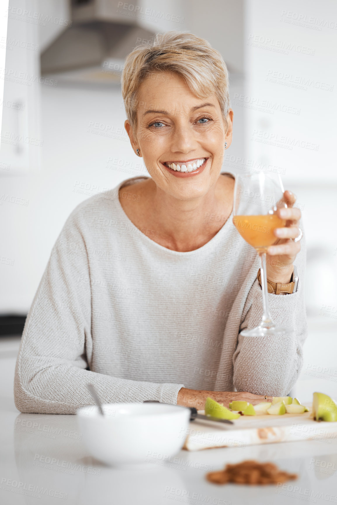 Buy stock photo Mature woman, juice and fruit in portrait with smile for breakfast, diet and wellness in morning. Person, glass and happy in home with drink for detox, nutrition and gut health with apple in France