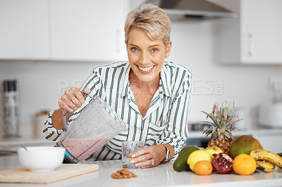 Buy stock photo Shot of a woman pouring her smoothie into a glass