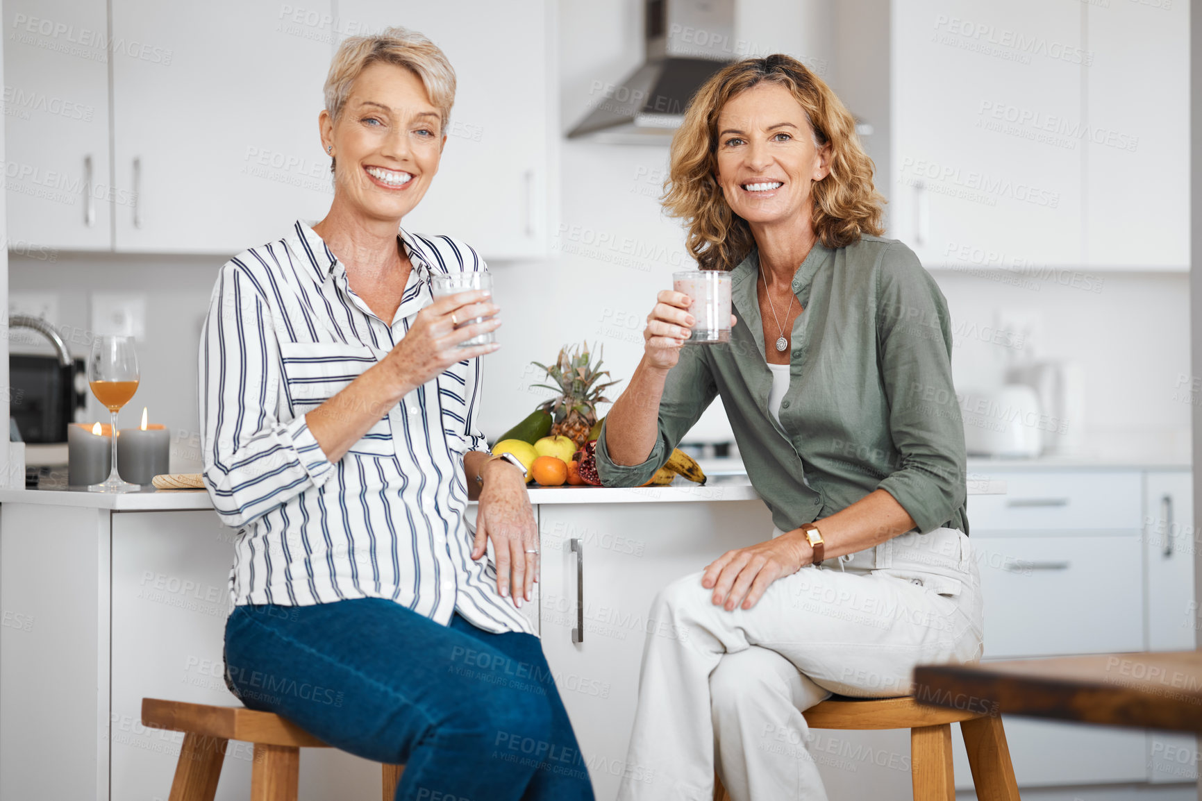 Buy stock photo Shot of two friends having juice and smoothies together