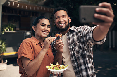 Buy stock photo Shot of two young friends standing outside a restaurant and using a cellphone to take a selfie