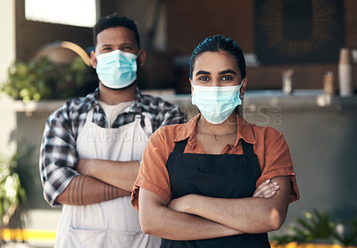 Buy stock photo Shot of two young restaurant owners standing outside together with her arms folded while wearing face masks