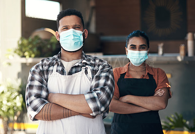 Buy stock photo Shot of two young restaurant owners standing outside together with her arms folded while wearing face masks