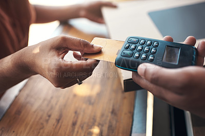 Buy stock photo Cropped shot of an unrecognizable woman using a credit card machine to pay for her meal at a restaurant