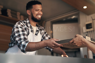 Buy stock photo Shot of a young man standing behind the counter in his restaurant and giving a customer her freshly made pizza