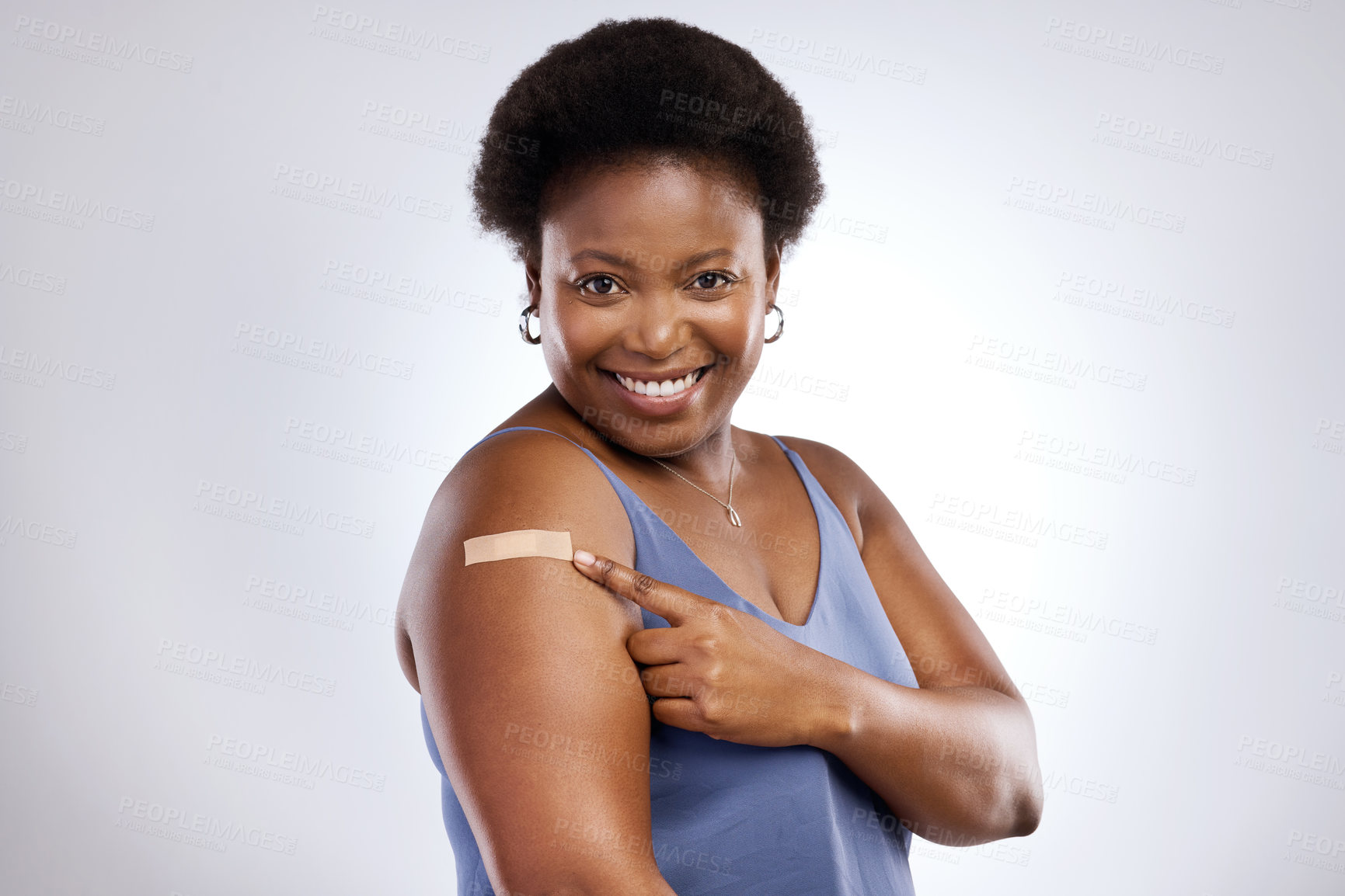 Buy stock photo Studio shot of a young woman after receiving the Covid-19 vaccine against a grey background