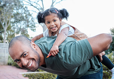 Buy stock photo Shot of a man carrying his daughter on his back while standing outside
