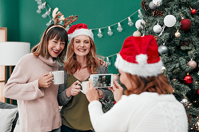 Buy stock photo Shot of three attractive woman taking Christmas pictures together at home