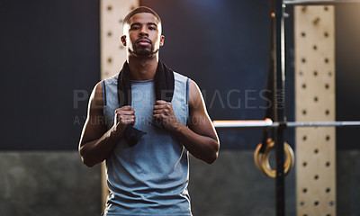 Buy stock photo Portrait of a muscular young man standing with a towel around his neck in a gym