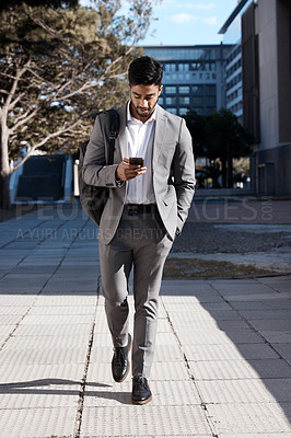 Buy stock photo Phone, city and Indian business man walking for travel, social media or internet search. Smartphone, texting and male person on walk in town while checking app, message or text on commute in street