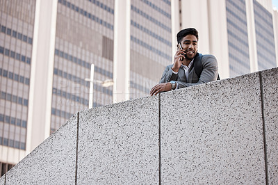 Buy stock photo Shot of a young businessman on a call in the city