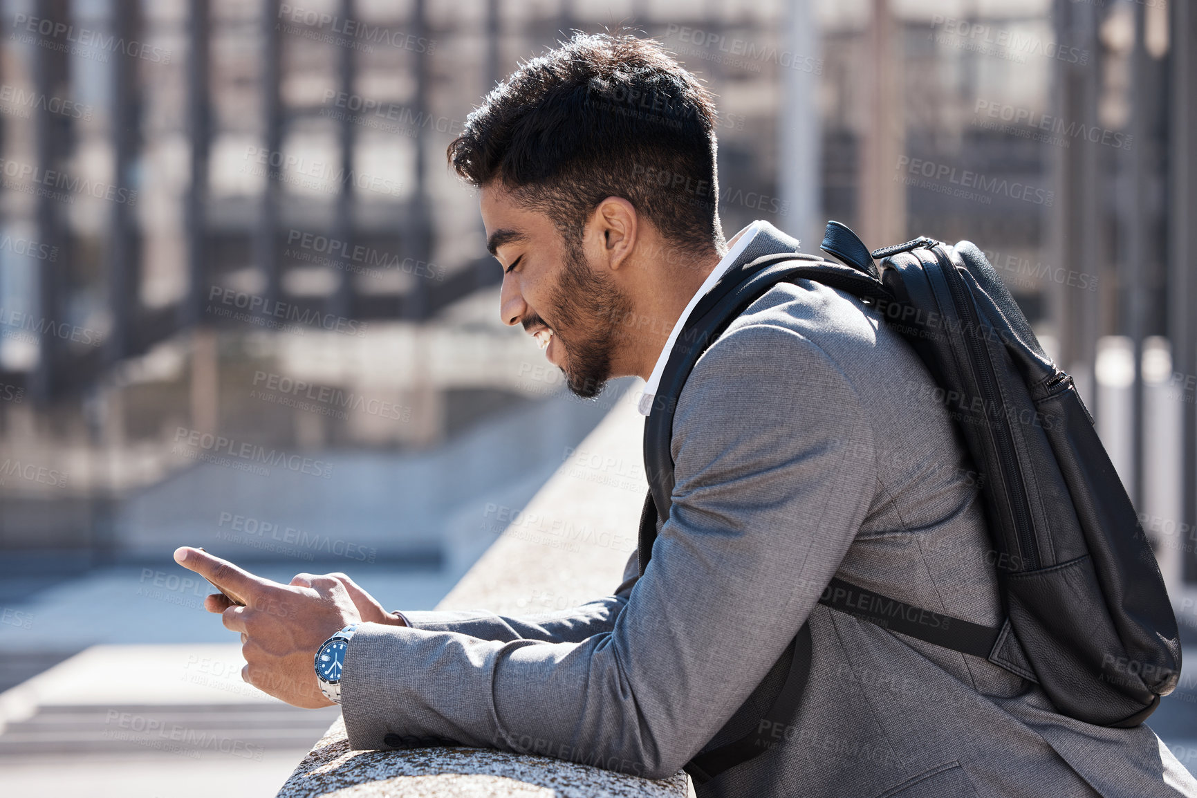 Buy stock photo Shot of a young businessman using a phone in the city