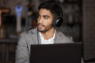 Buy stock photo Business man, thinking and cafe for remote work with headphones on laptop, planning and report. Young indian businessman, solution and brainstorming for ideas, web design and music in coffee shop