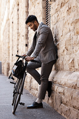 Buy stock photo Bicycle, relax and happy business man in city for carbon neutral, sustainable and transport. Bike, commute and Indian male person on cycling break, smile and resting while traveling alone in Europe