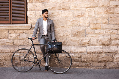 Buy stock photo Bicycle, suit and businessman in the city for travel standing by a brick wall building. Briefcase, professional and young male employee riding a bike or commuting to his work office in an urban town.