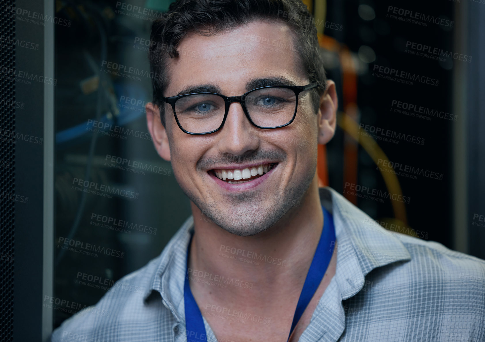 Buy stock photo Cropped portrait of a handsome young male programmer working in a server room