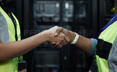 Buy stock photo Cropped shot of two unrecognizable female programmers shaking hands in a server room