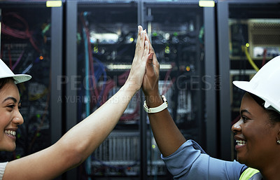 Buy stock photo Cropped shot of two attractive female programmers high fiving in a server room