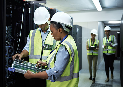 Buy stock photo Cropped shot of a group of computer programmers working in a server room