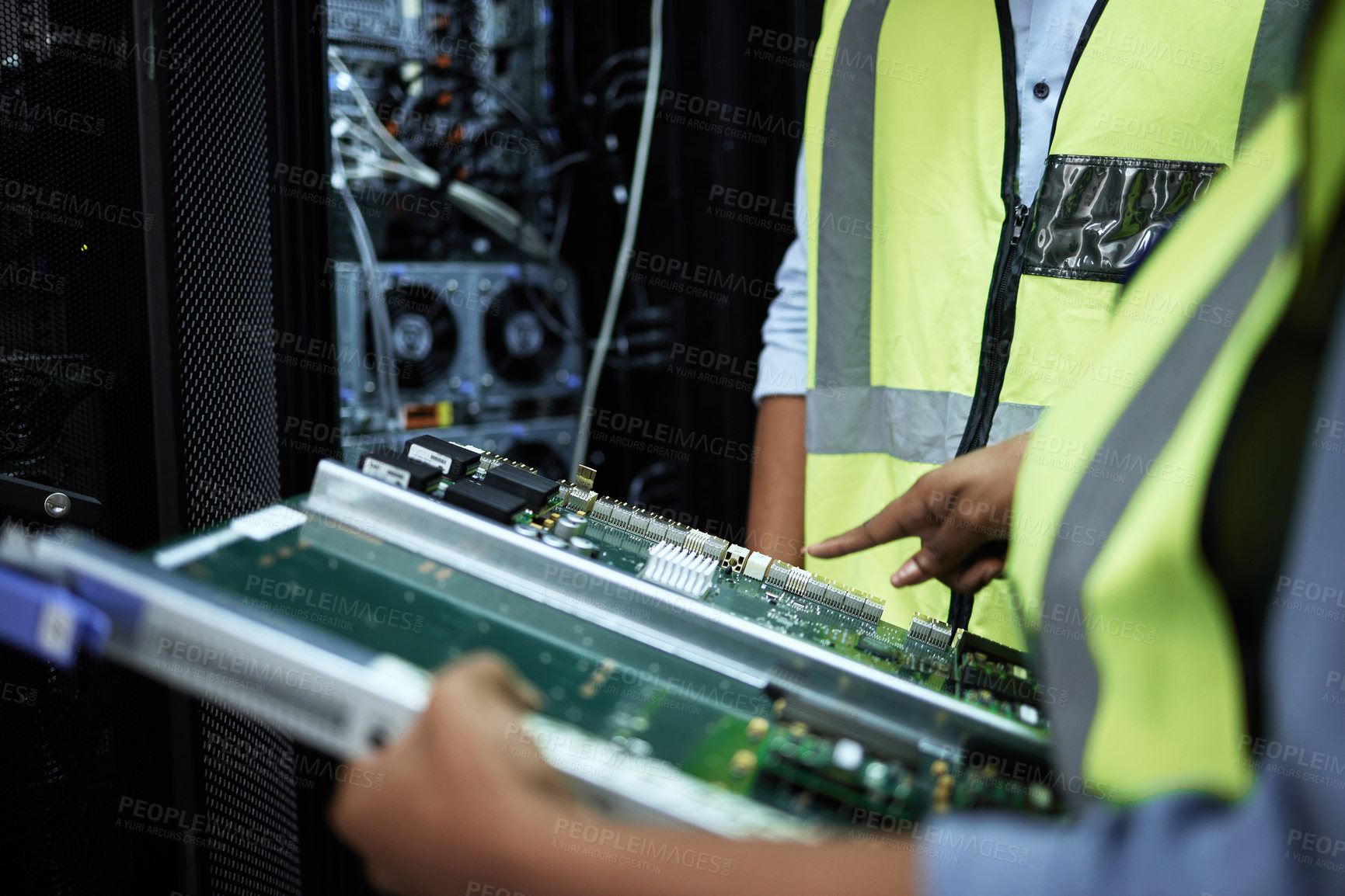 Buy stock photo Cropped shot of two unrecognizable computer programmers working in a server room