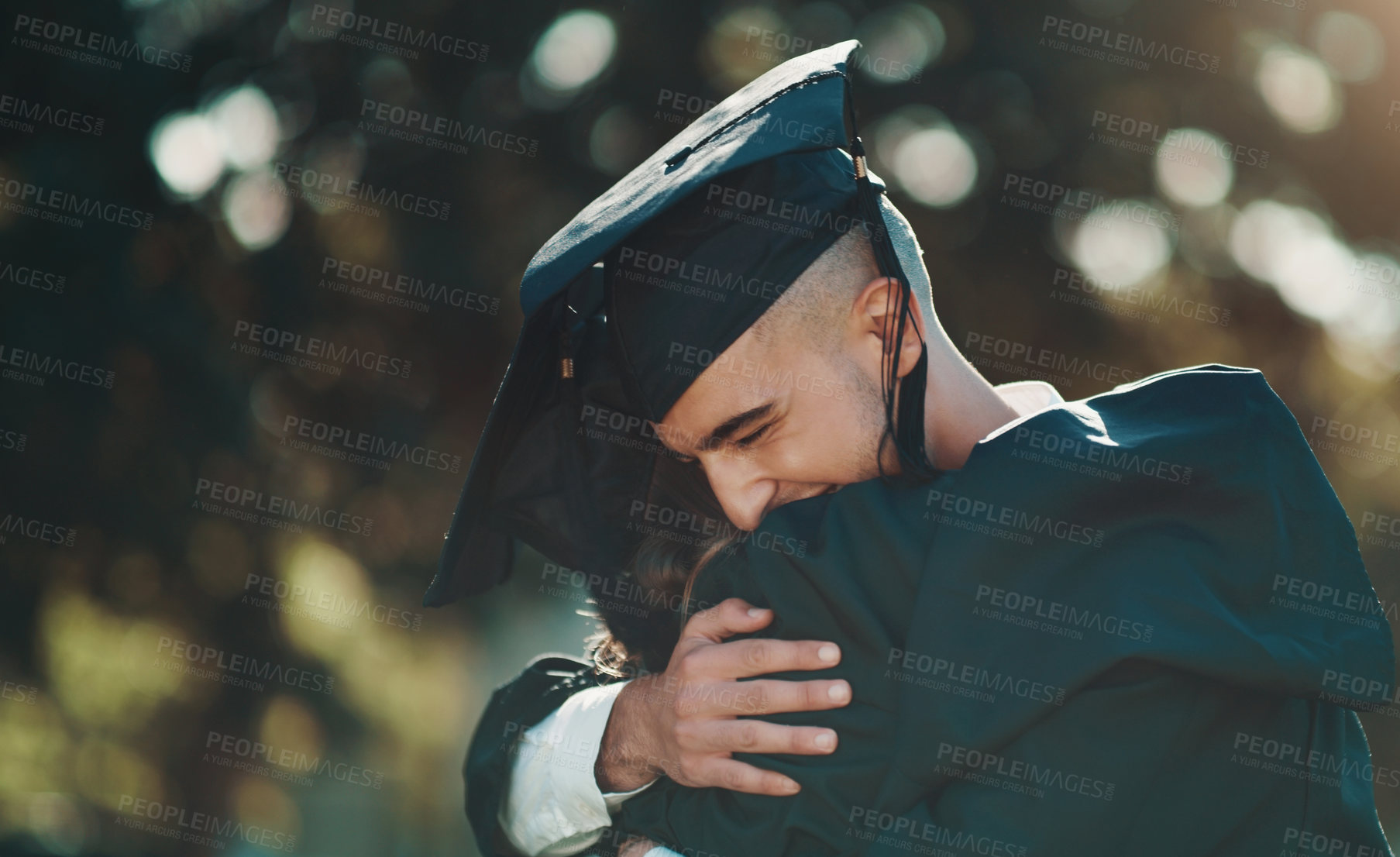 Buy stock photo Shot of two students sharing a hug on graduation day