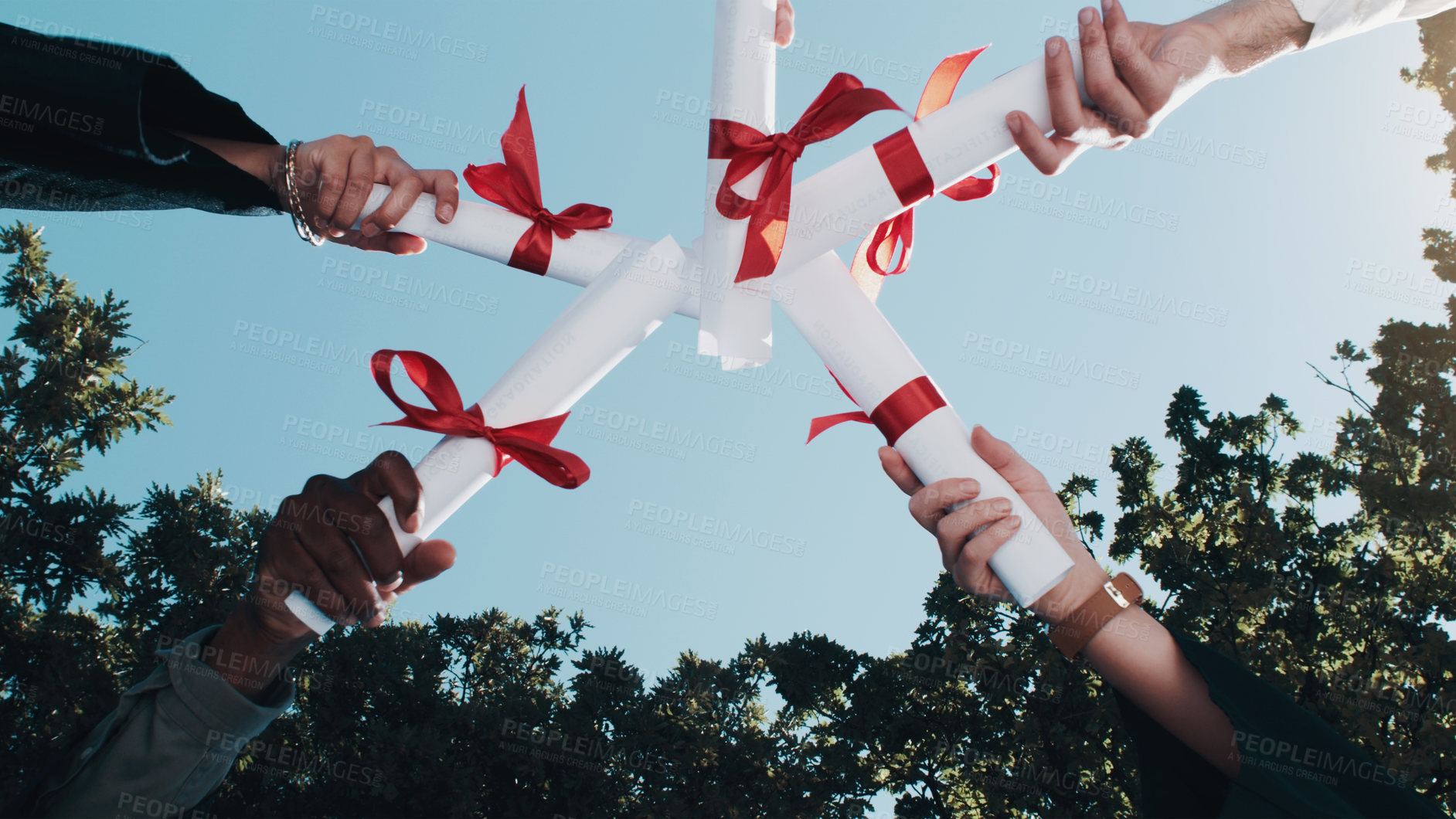 Buy stock photo Shot of a group of students standing in a huddle with their diplomas on graduation day