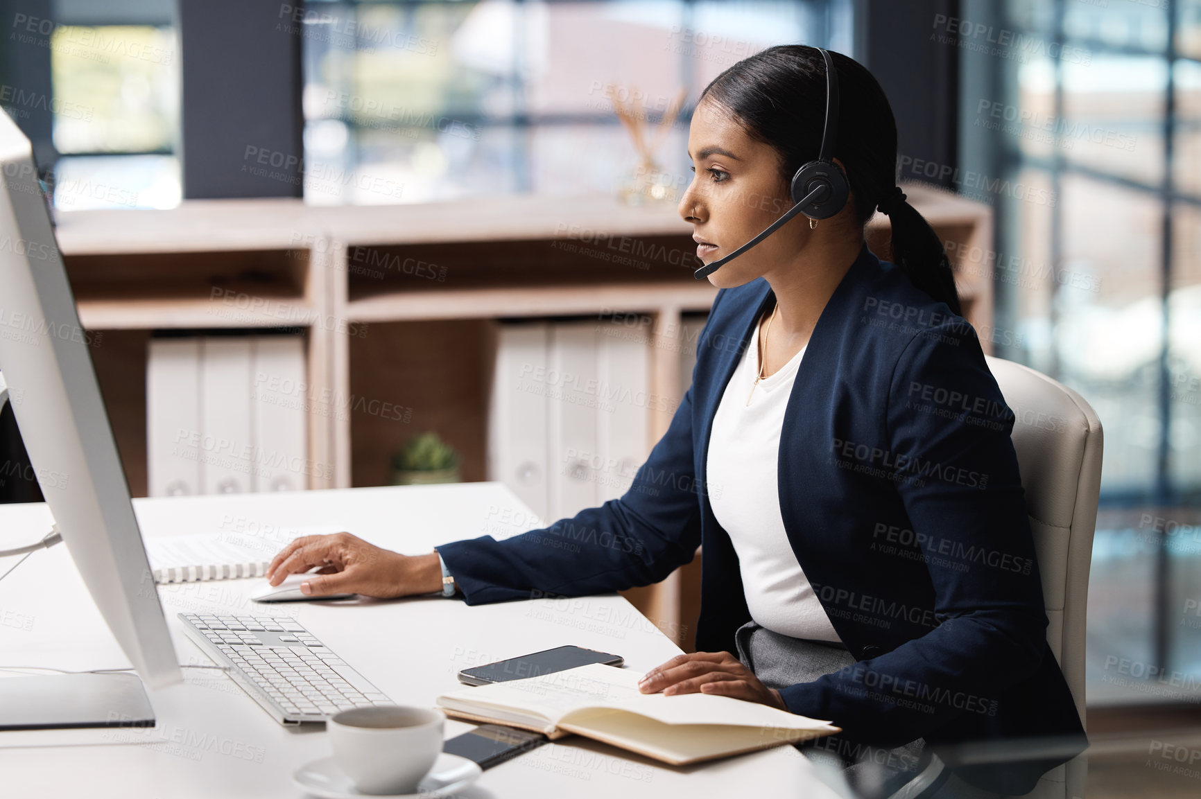 Buy stock photo Shot of a young businesswoman working on a computer in a call centre