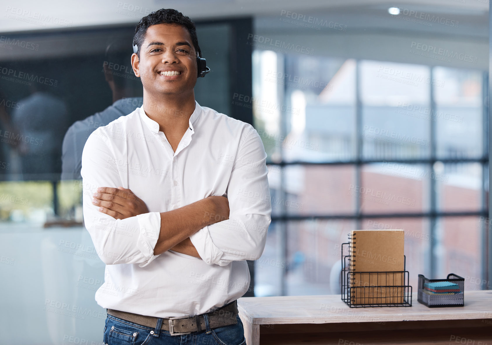 Buy stock photo Portrait of a young businessman standing with his arms crossed in a call centre