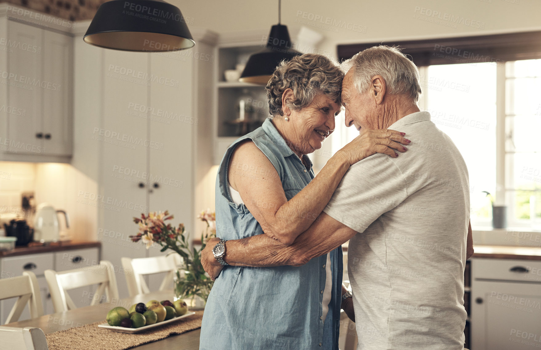 Buy stock photo Shot of a senior couple dancing in the kitchen at home