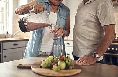 Buy stock photo Shot of a senior couple making a smoothie in the kitchen at home