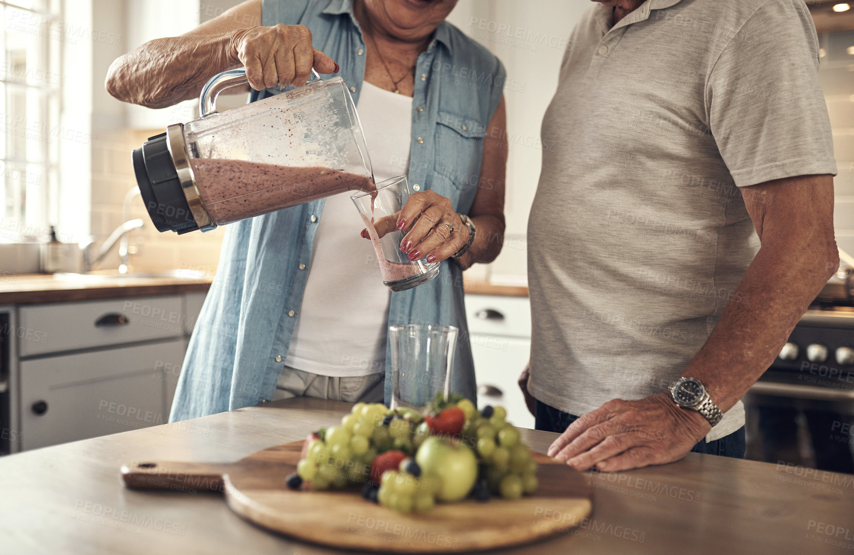 Buy stock photo Shot of a senior couple making a smoothie in the kitchen at home