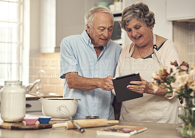 Buy stock photo Shot of a senior couple using a digital tablet while baking at home